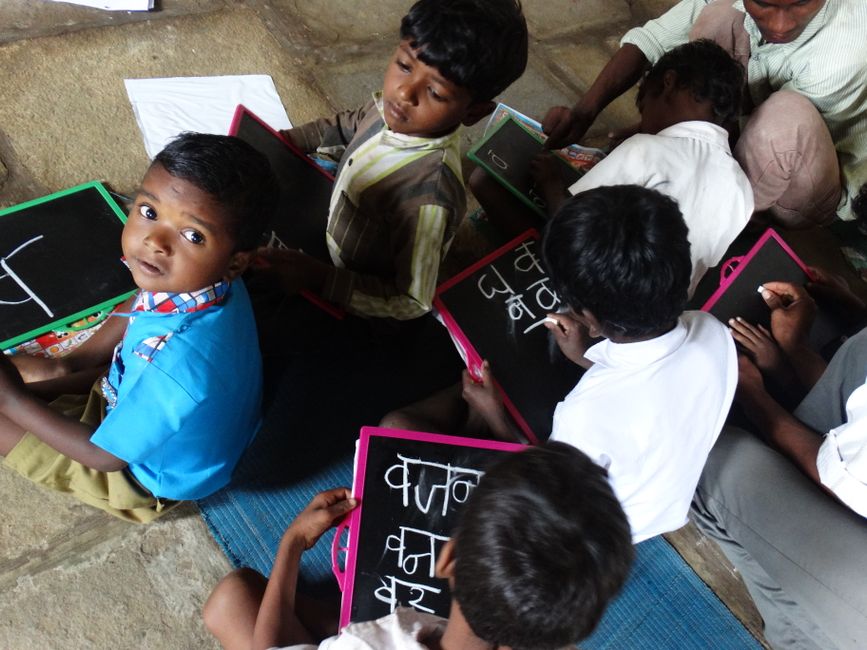 Young students writing on slates in a village school in Melghat, India.